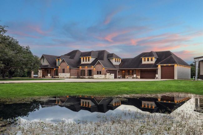 This custom-designed brick and stone main home sits on 5.13 acres, complete with a stunning over one-acre pond in the rear that connects to a smaller pond at the front. The ponds create a peaceful, natural setting where wildlife, including deer, can often be seen drinking and enjoying the serene surroundings. The perfect backdrop for this beautiful home, offering both privacy and a constant connection to nature. | Image 50