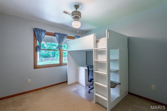 Unfurnished bedroom with carpet flooring and an office area | Image 17