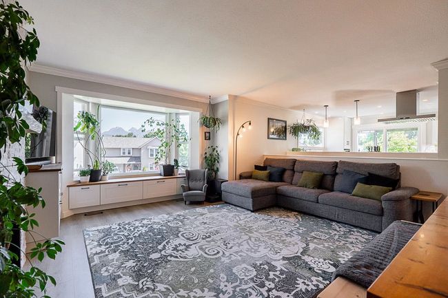 Living room featuring crown molding, light wood grain flooring & mountain view | Image 5