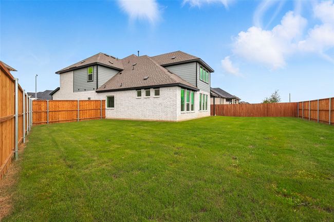 Back of house featuring brick siding, roof with shingles, and a fenced backyard | Image 31