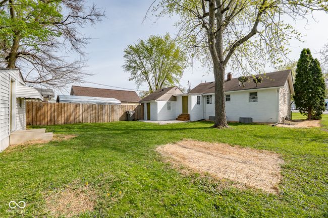 back of property with fence, entry steps, a yard, central air condition unit, and brick siding | Image 31