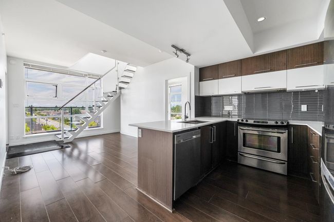 Kitchen with appliances with stainless steel finishes, a peninsula, dark wood finished floors, decorative backsplash, and recessed lighting | Image 9