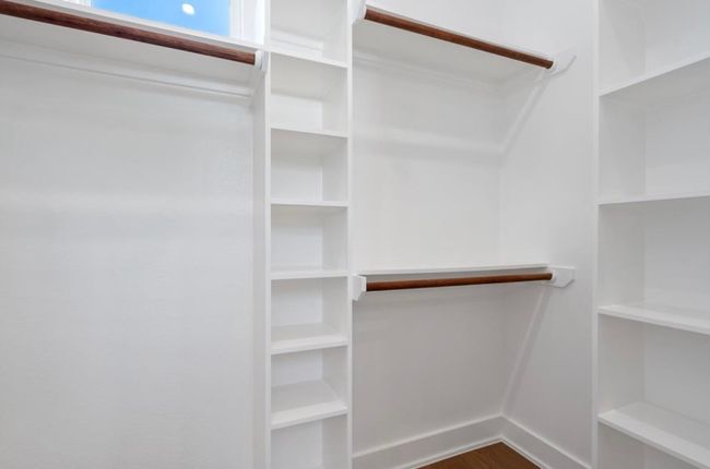 Spacious closet with dark wood-style floors | Image 18