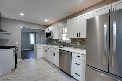 Kitchen featuring appliances with stainless steel finishes, white cabinets, and a wealth of natural light | Image 2