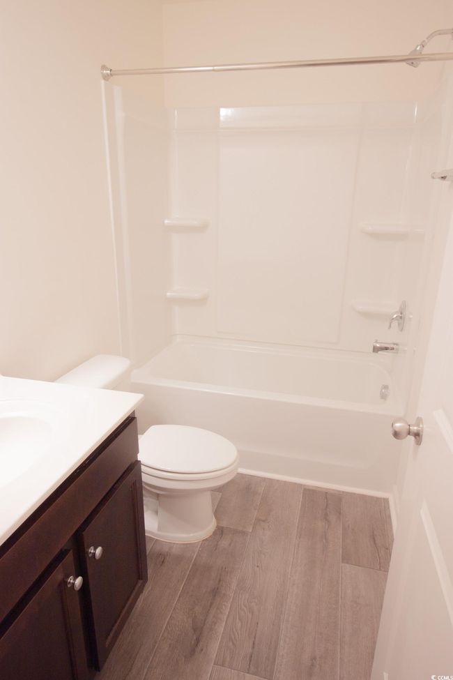 Bathroom with vanity, wood finished floors, toilet, and tub / shower combination | Image 14
