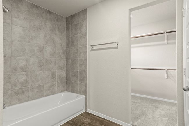 Bathroom with a spacious closet, shower combination, and wood finished floors | Image 27
