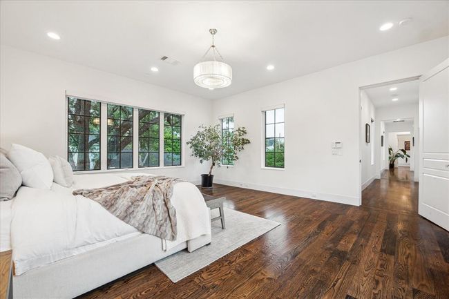 PRIMARY BEDROOM. Restoration Hardware lighting is included. Note the hardwoods continue throughout the entire home | Image 16