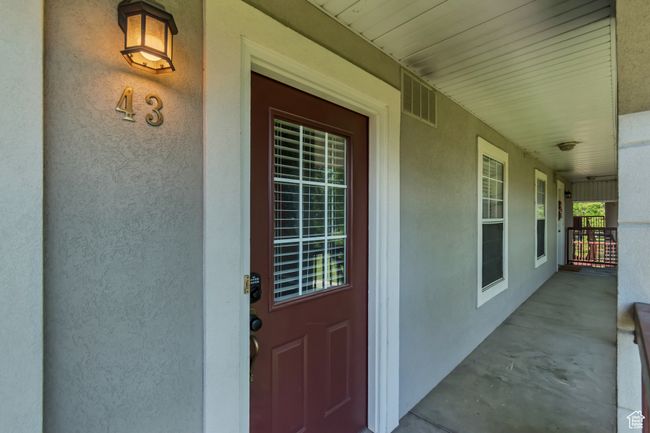 Doorway to property featuring stucco siding and a porch | Image 15