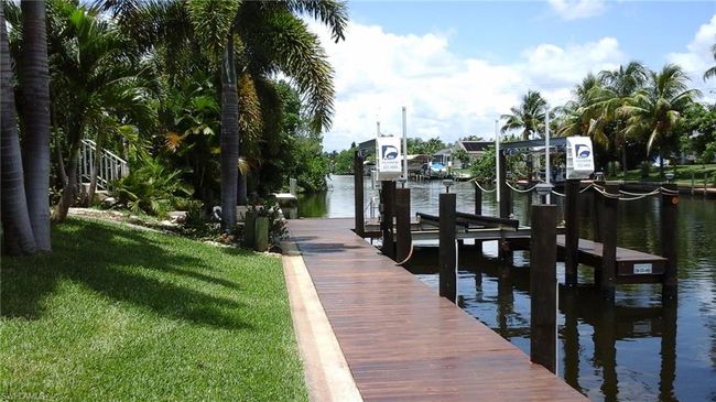 View of dock featuring boat lift, a yard, and a water view | Image 38