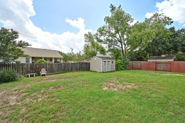 Fenced backyard with a storage unit | Image 34
