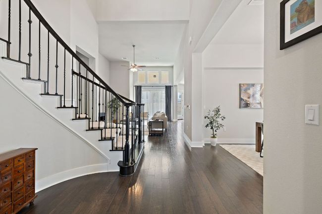 Sweeping curved staircase at the foyer, high ceilings, wood flooring | Image 4