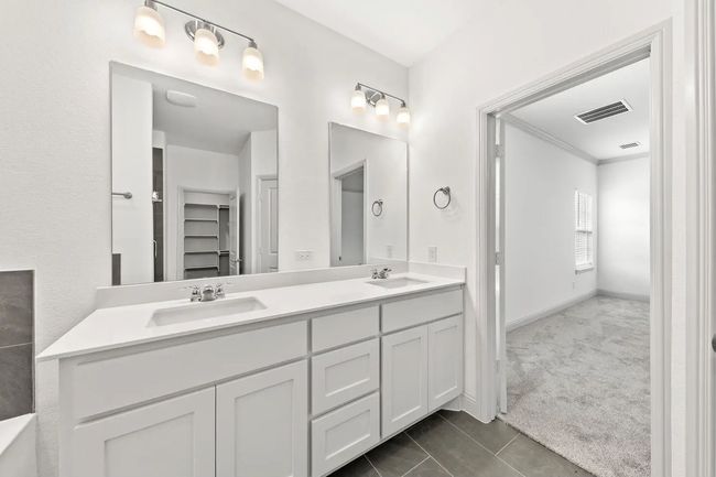 Full bath with double vanity, tile patterned flooring, and crown molding | Image 9