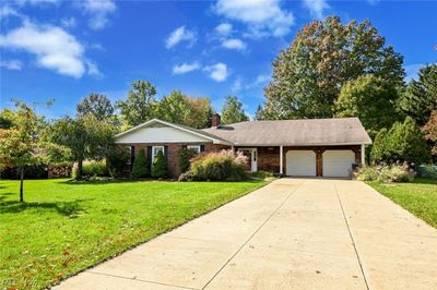 Ranch-style home with a front yard and a garage | Image 1