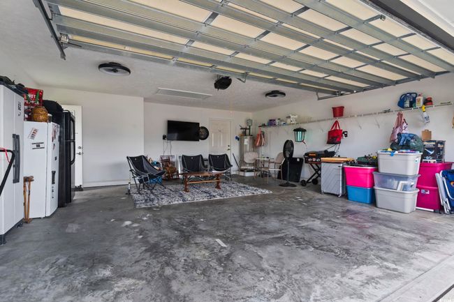Garage with white fridge with ice dispenser and electric water heater | Image 29
