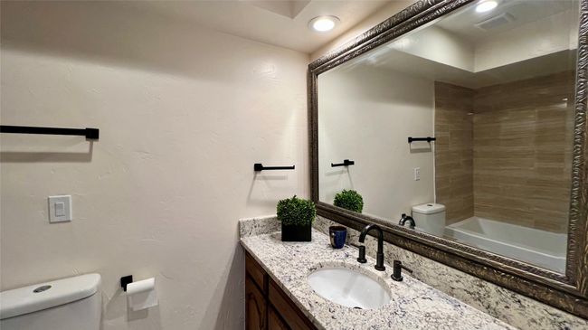 Bathroom featuring vanity and washtub / shower combination | Image 15