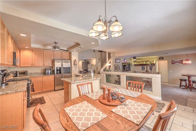 Dining area with a ceiling fan, light tile patterned floors, a chandelier, recessed lighting, and a raised ceiling | Image 26
