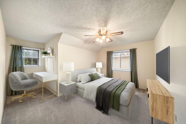The upstairs bedroom offers a flexible layout with space for both a bed and a dedicated work or study area, featuring neutral carpet and dual windows for natural light. This photo has been virtually staged. | Image 26