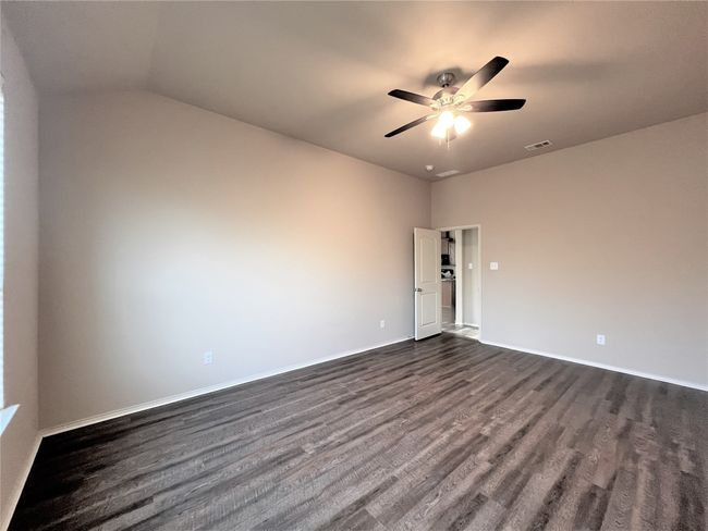 Unfurnished room with dark wood-type flooring, ceiling fan, and vaulted ceiling | Image 14