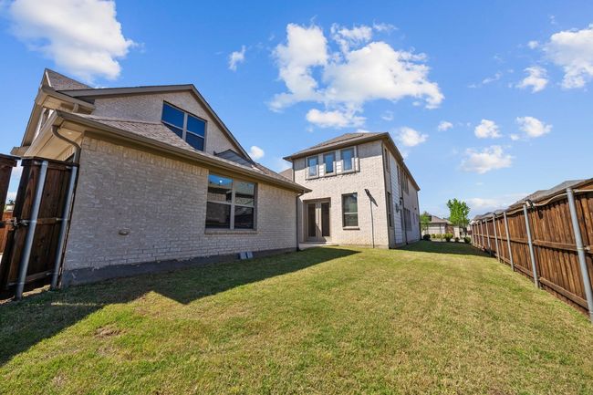 Rear view of property featuring brick siding, a lawn, and a fenced backyard | Image 23