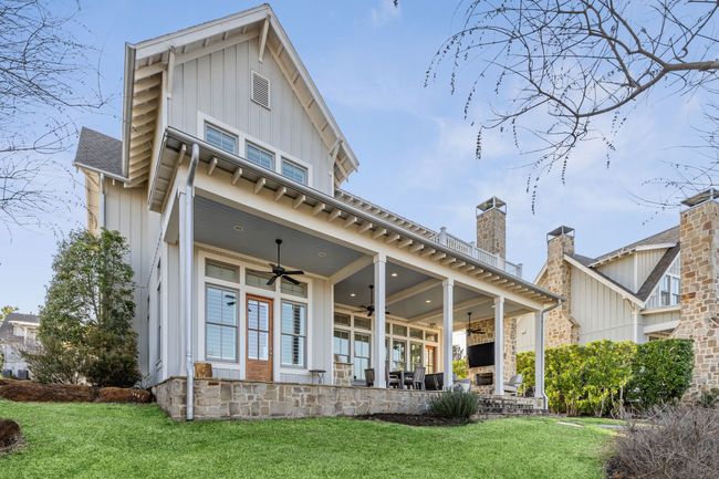 Rear view of property with a ceiling fan, board and batten siding, a yard, and a patio area | Image 34