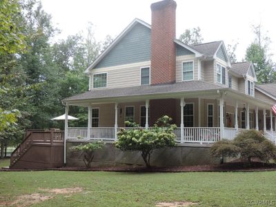 Farmhouse inspired home featuring covered porch and a front lawn | Image 2