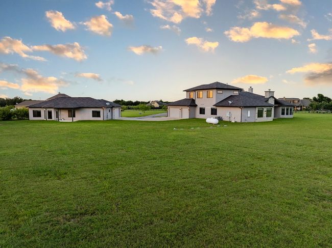 Rear view of property with driveway, an attached garage, and a yard | Image 40