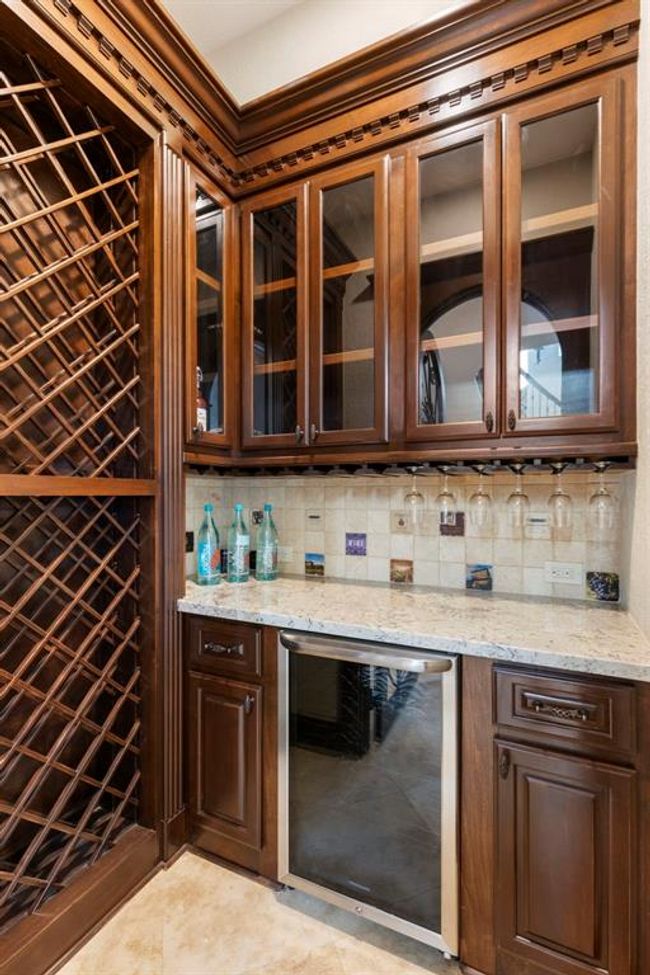 Elegant Built-In Wine Cellar: Indulge in the luxury of a custom wine storage, beautifully crafted with rich wood detailing and seamless glass cabinetry, perfect for the discerning collector. | Image 8