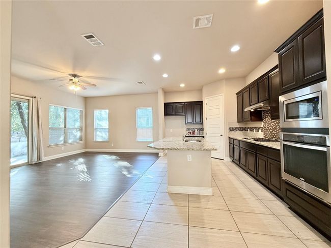 Kitchen with recessed lighting, open floor plan, stainless steel appliances, plenty of natural light, and a ceiling fan | Image 4