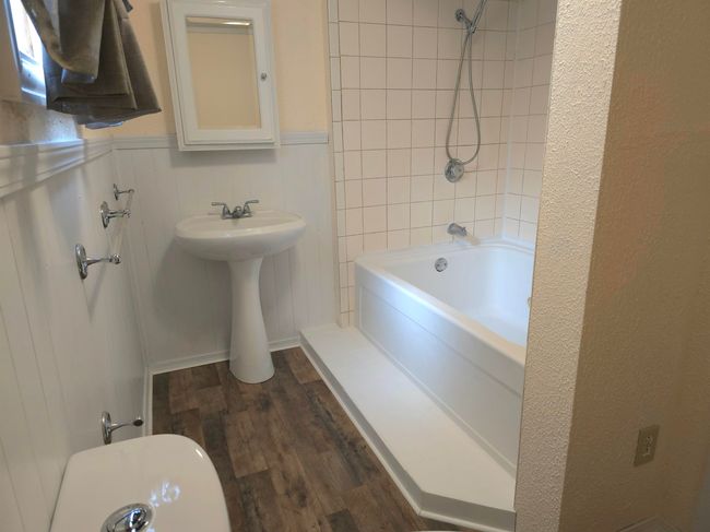 Bathroom with tiled shower / bath and hardwood / wood-style flooring | Image 15