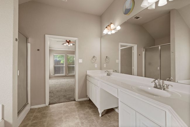 Bathroom featuring visible vents, a sink, a shower stall, and double vanity | Image 23