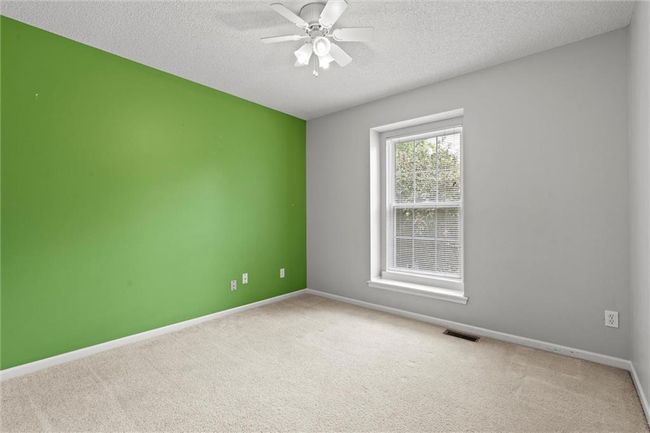 Carpeted empty room featuring a textured ceiling and ceiling fan | Image 24