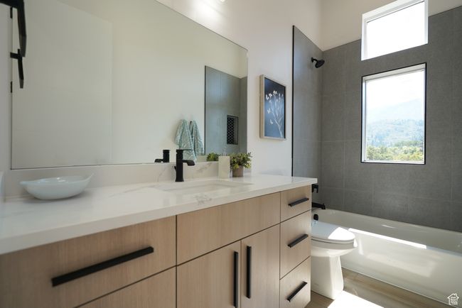 Full bath with toilet, vanity, shower / bathtub combination, and wood finished floors | Image 18