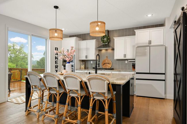 Kitchen has a large center island, ample cabinetry, and new modern light fixtures. | Image 17