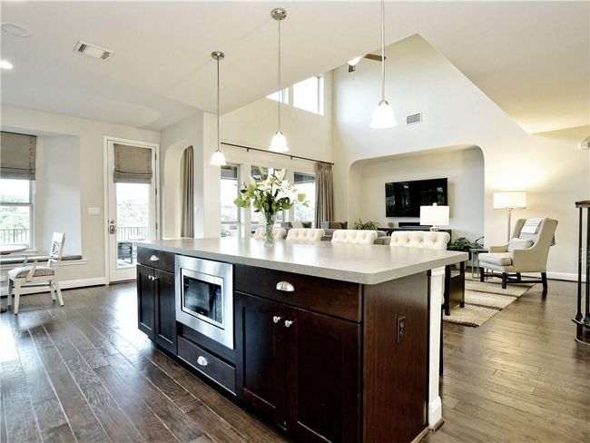 Kitchen with stainless steel microwave, arched walkways, healthy amount of natural light, and dark wood-style flooring | Image 19