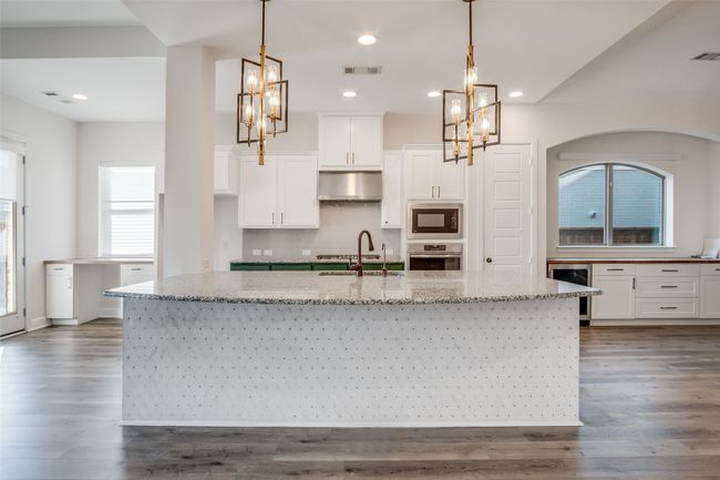 Kitchen featuring built in microwave, oven, wine cooler, a chandelier, and recessed lighting | Image 11