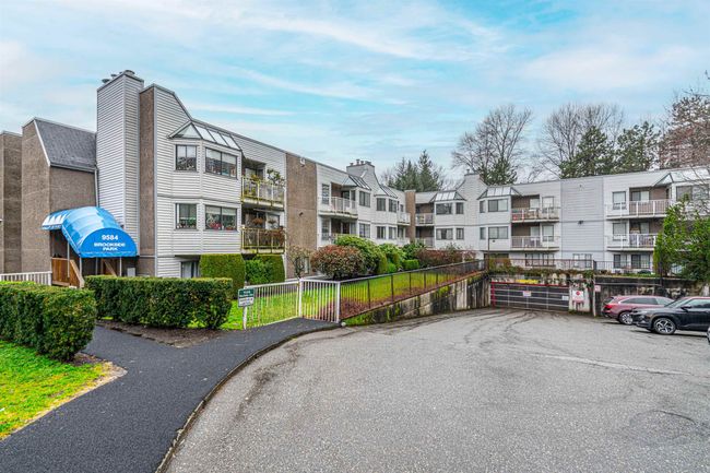 View of building exterior featuring fence and uncovered parking | Image 25