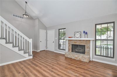 Living room featuring high vaulted ceiling, a fireplace | Image 2