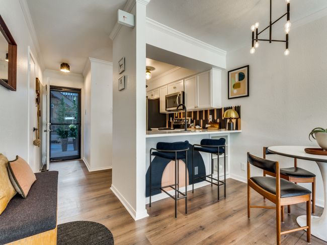 Dining room with crown molding, wood finished floors, a chandelier, and baseboards | Image 5