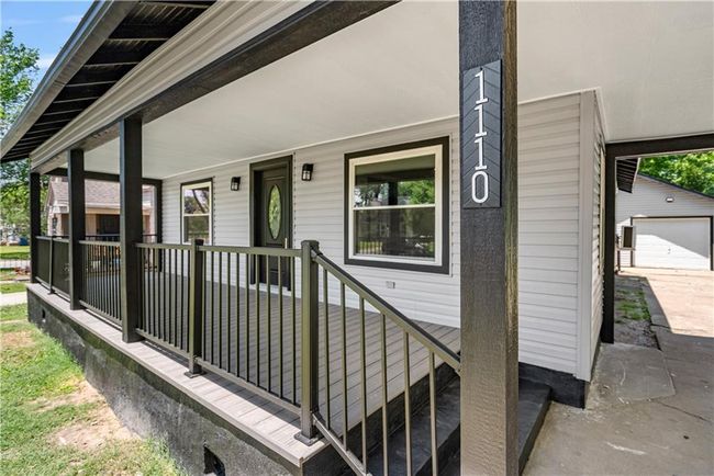 Property entrance featuring covered porch and a garage | Image 9