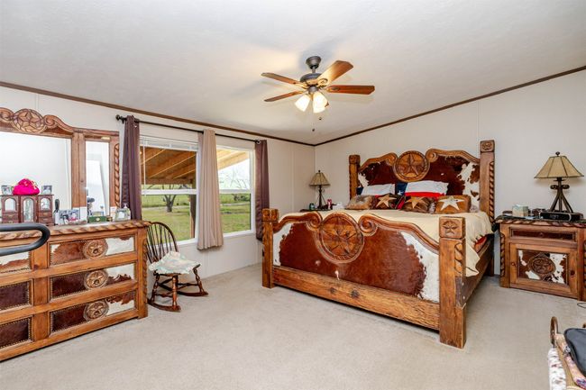 Bedroom with ornamental molding, ceiling fan, and carpet | Image 18