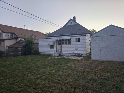 Back house at dusk featuring a yard | Image 2