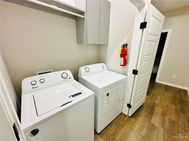 Laundry area with wood finished floors and washer and clothes dryer | Image 10