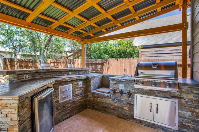 Fenced backyard featuring an outdoor kitchen and a patio area | Image 24