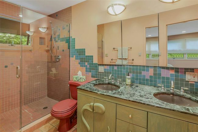 Full bath with a shower stall, double vanity, toilet, tile patterned floors, and tile walls | Image 20