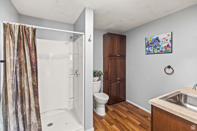 Bathroom with a shower with curtain, toilet, wood-type flooring, and vanity | Image 17