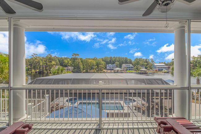 Swimming pool featuring a ceiling fan, a water view, and an in-ground hot tub | Image 36