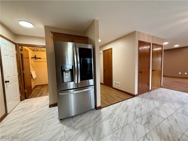 Kitchen featuring stainless steel fridge, baseboards, light marble finish floors, and recessed lighting | Image 9