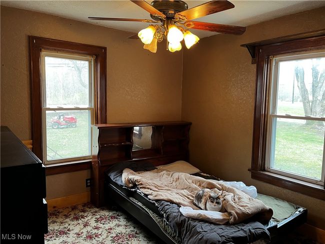 Bedroom with a textured wall and a ceiling fan | Image 11