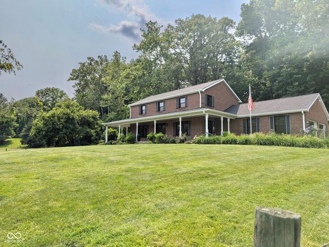 view of front of property with brick siding, a front lawn, and a porch | Image 12