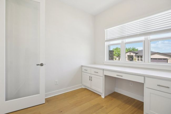 Unfurnished office with light wood-type flooring, built in desk, and baseboards | Image 28